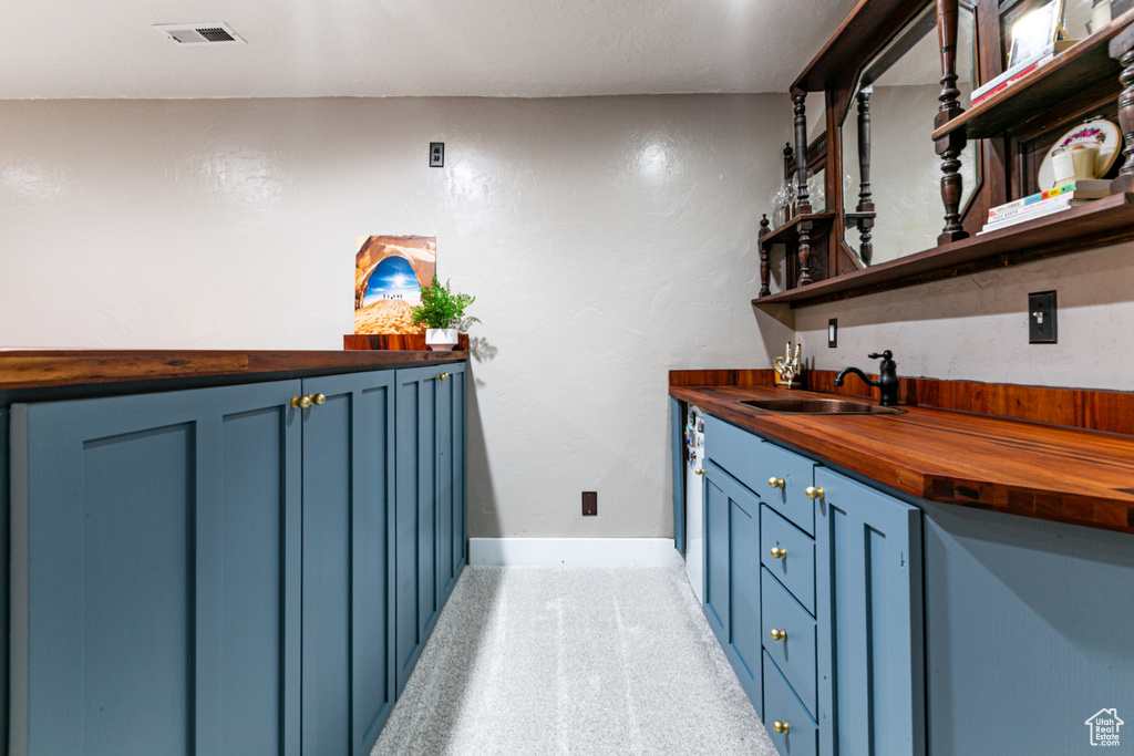 Indoor wet bar featuring baseboards and light colored carpet