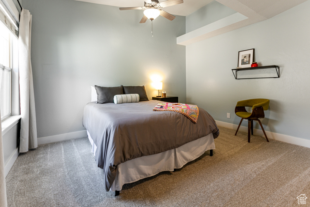 Carpeted bedroom featuring baseboards and ceiling fan