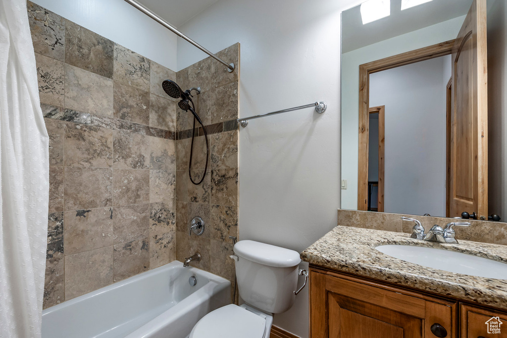 Full bath featuring shower / bath combo, toilet, and vanity