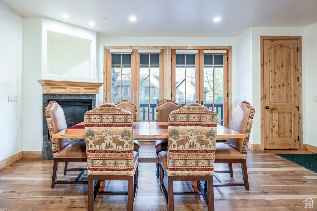 Dining area featuring plenty of natural light, a high end fireplace, light wood-type flooring, and recessed lighting