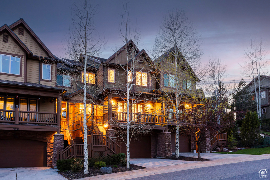 Craftsman-style house with stairway, an attached garage, and driveway