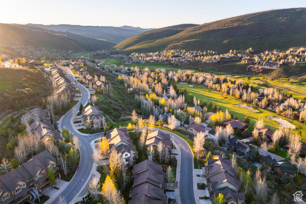Aerial view of property and surrounding area featuring nearby suburban area and a mountain backdrop