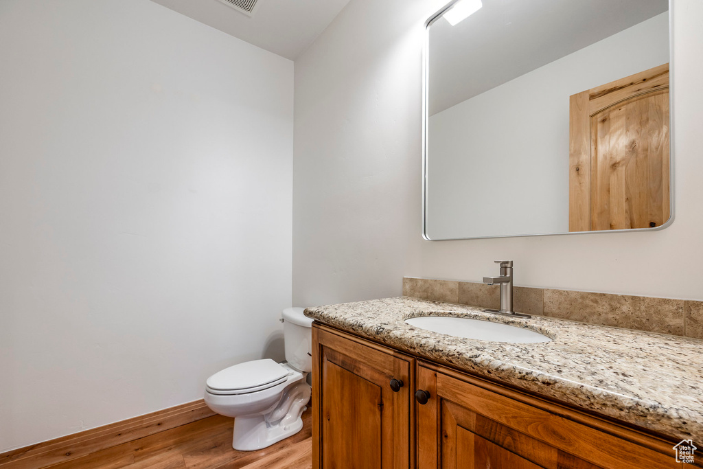 Bathroom with wood finished floors, toilet, and vanity