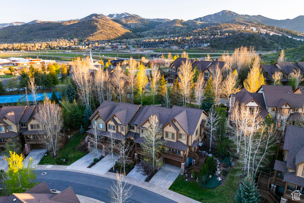 Aerial view of property and surrounding area with a mountainous background and nearby suburban area