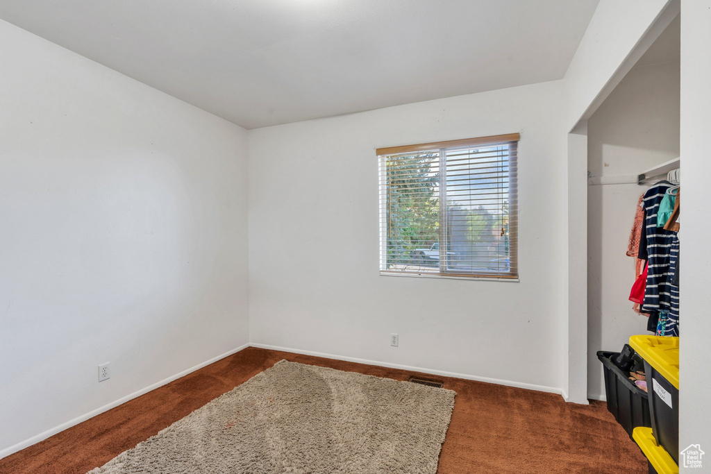 Unfurnished bedroom with carpet flooring and baseboards