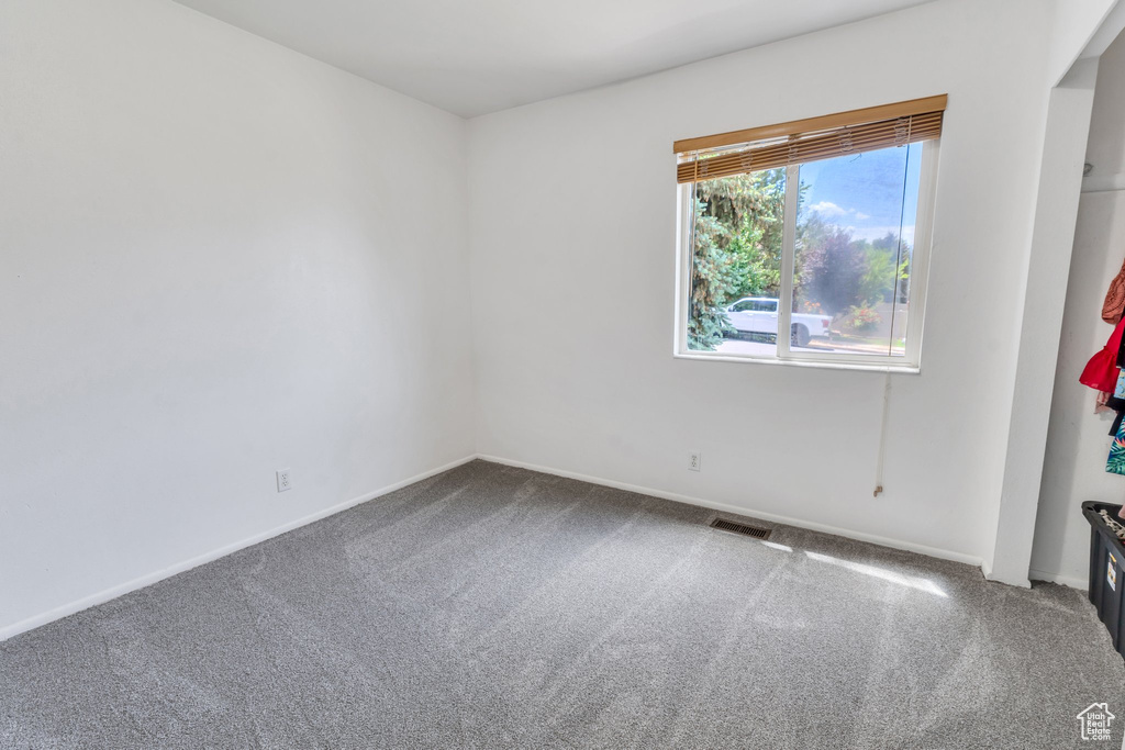 Empty room featuring carpet flooring and baseboards