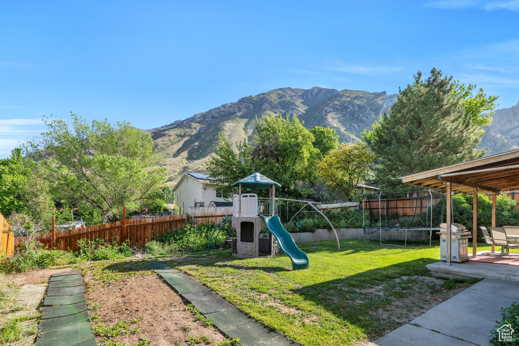 View of play area with a mountain view and a trampoline