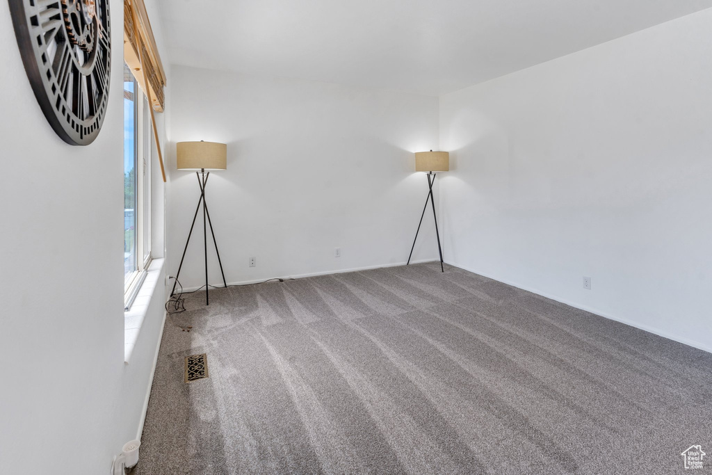 Spare room featuring carpet flooring and baseboards