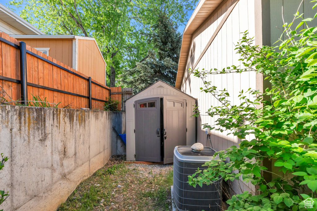 View of shed with cooling unit and fence