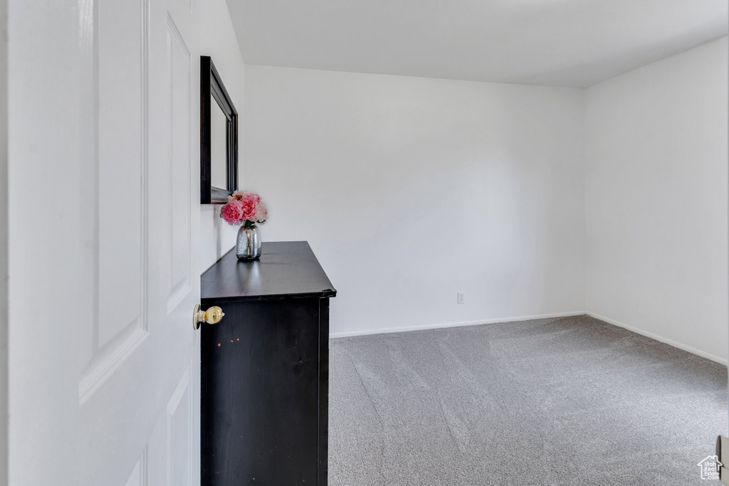 Carpeted spare room featuring baseboards