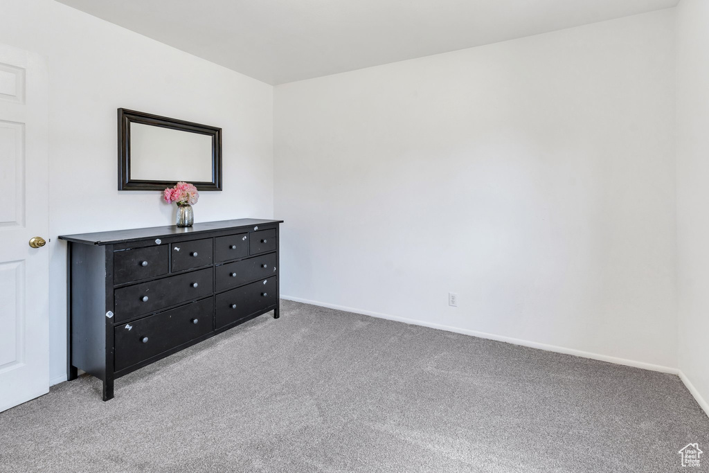 Bedroom with light colored carpet and baseboards