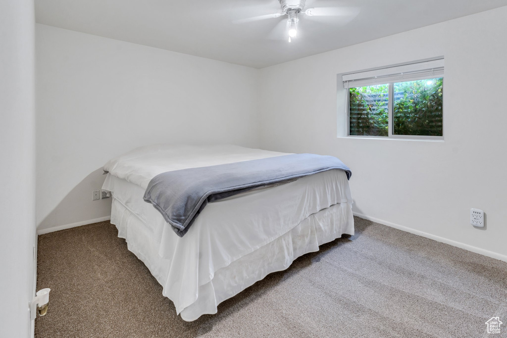 Bedroom featuring carpet floors, baseboards, and ceiling fan