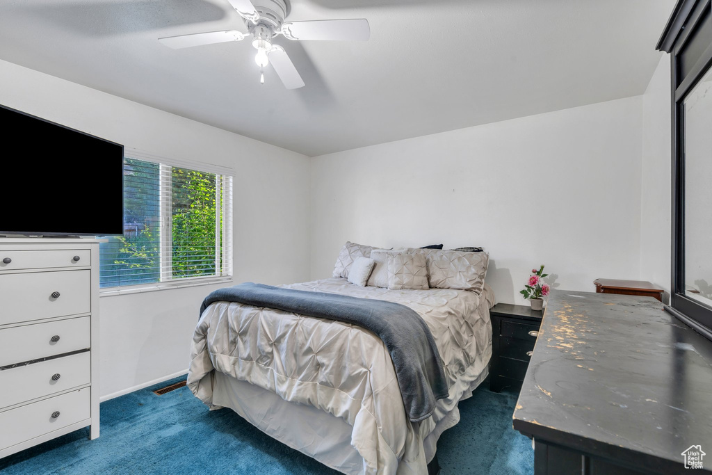 Carpeted bedroom featuring a ceiling fan and baseboards