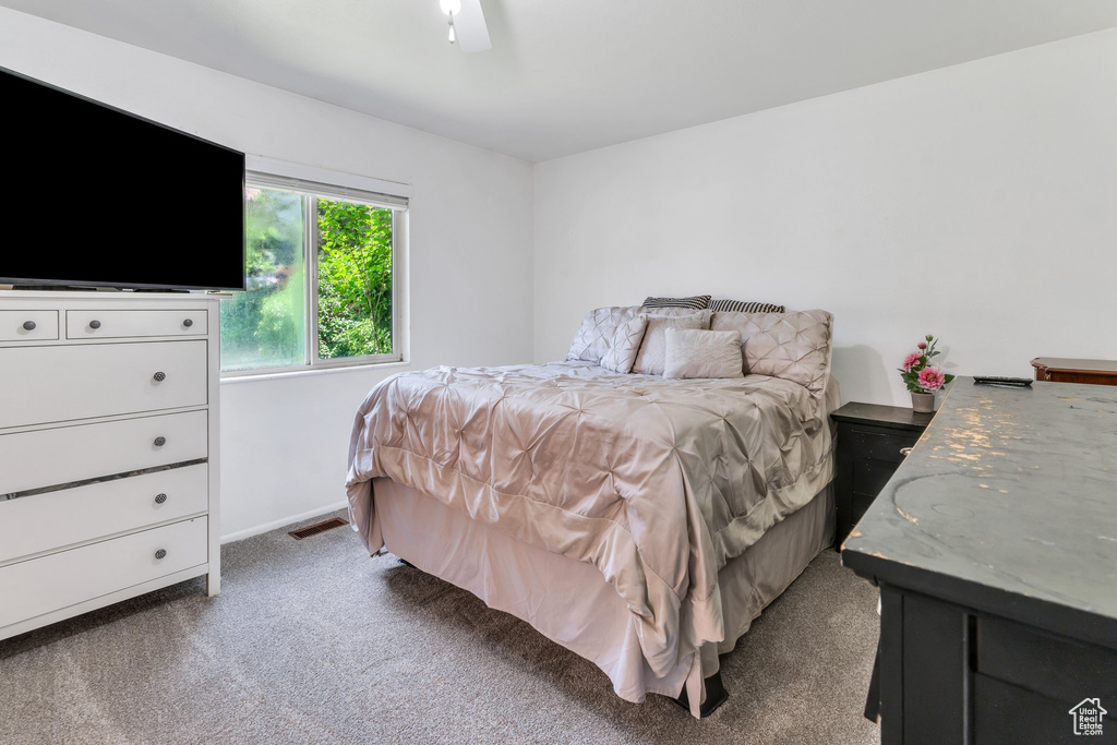 Carpeted bedroom featuring a ceiling fan