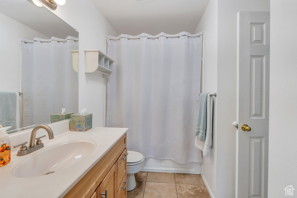 Full bathroom featuring toilet, tile patterned floors, vanity, and shower / bath combination with curtain
