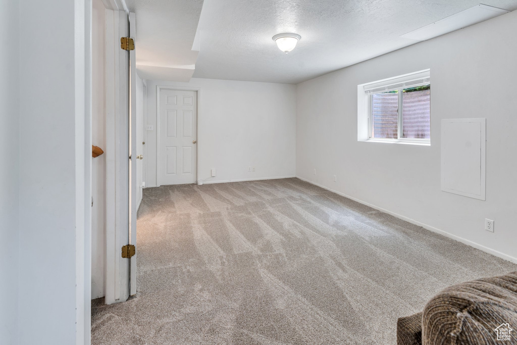 Unfurnished bedroom with carpet, baseboards, and a textured ceiling