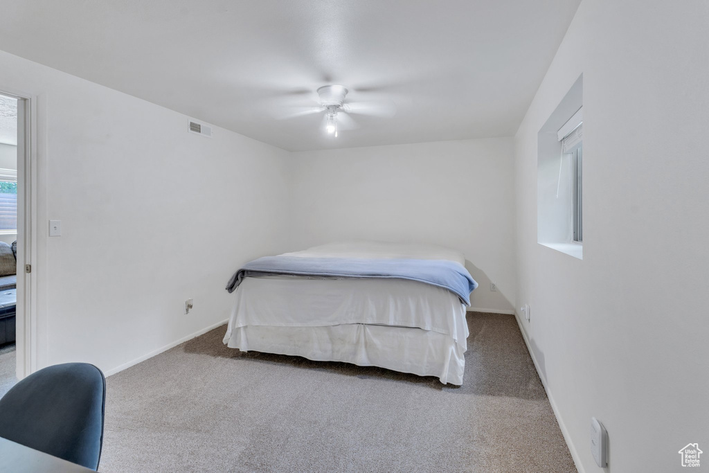 Bedroom with carpet flooring, baseboards, and a ceiling fan