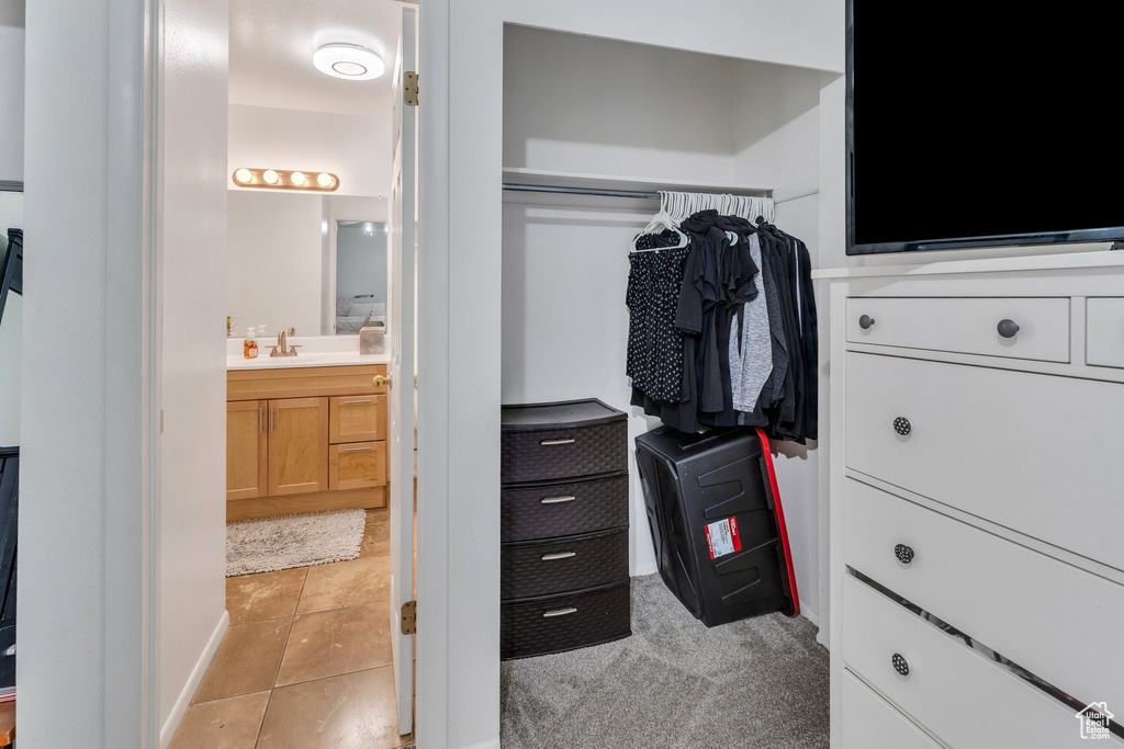 Spacious closet featuring a sink and light tile patterned floors