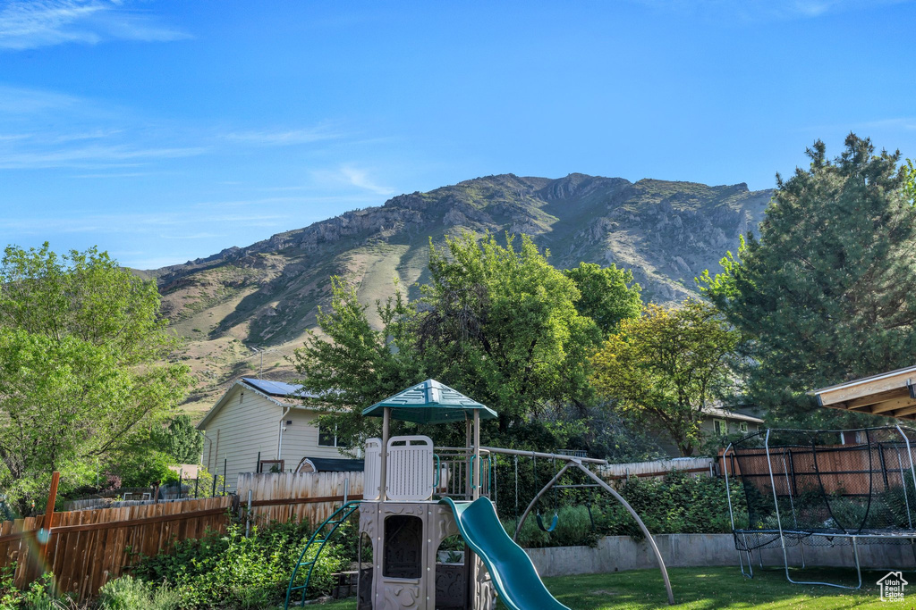 View of playground featuring a mountain view and a trampoline