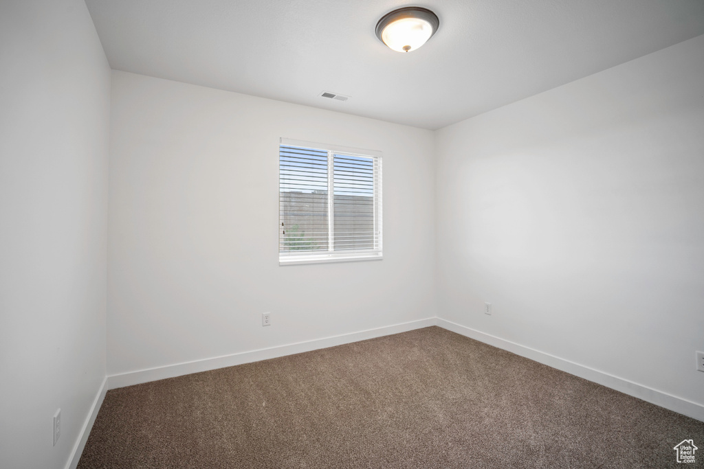 Carpeted empty room with baseboards
