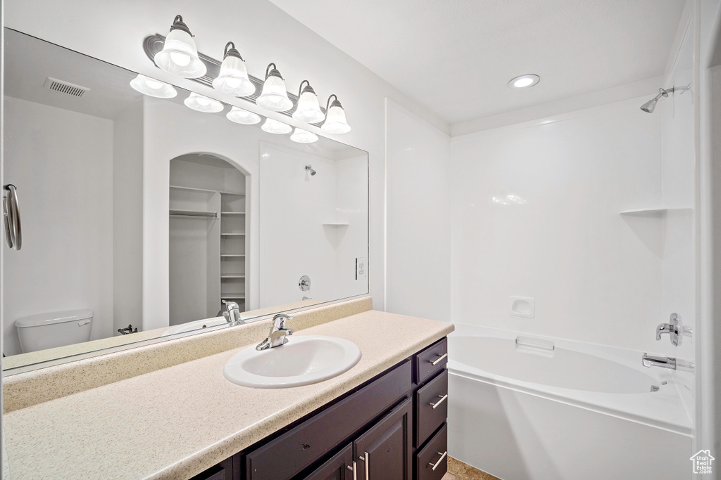 Full bathroom with vanity, toilet, bathing tub / shower combination, and a spacious closet