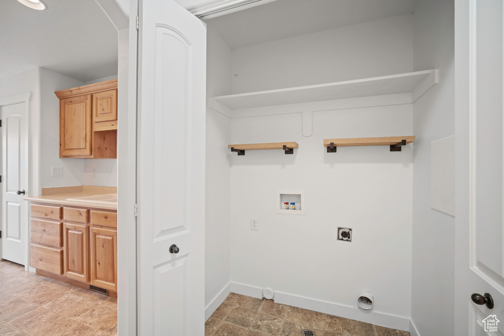 Laundry area with electric dryer hookup, hookup for a washing machine, arched walkways, and baseboards