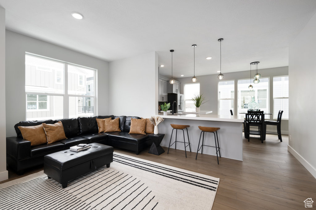 Living area featuring plenty of natural light, baseboards, wood finished floors, and recessed lighting