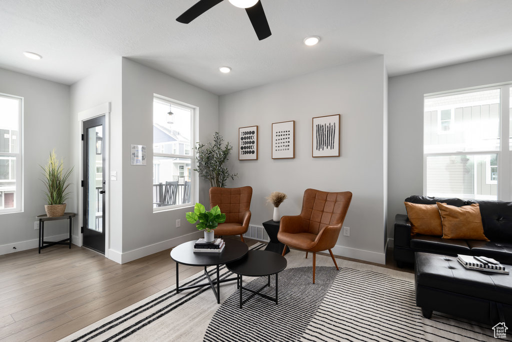 Sitting room featuring light wood finished floors, a ceiling fan, baseboards, and recessed lighting