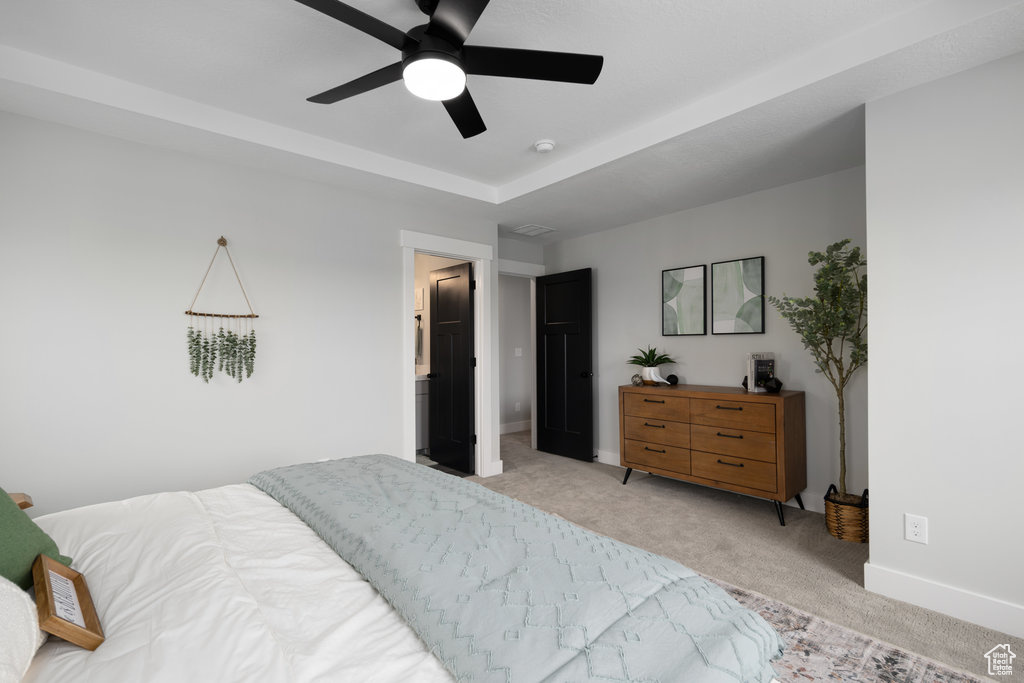 Bedroom featuring light colored carpet, baseboards, and ceiling fan