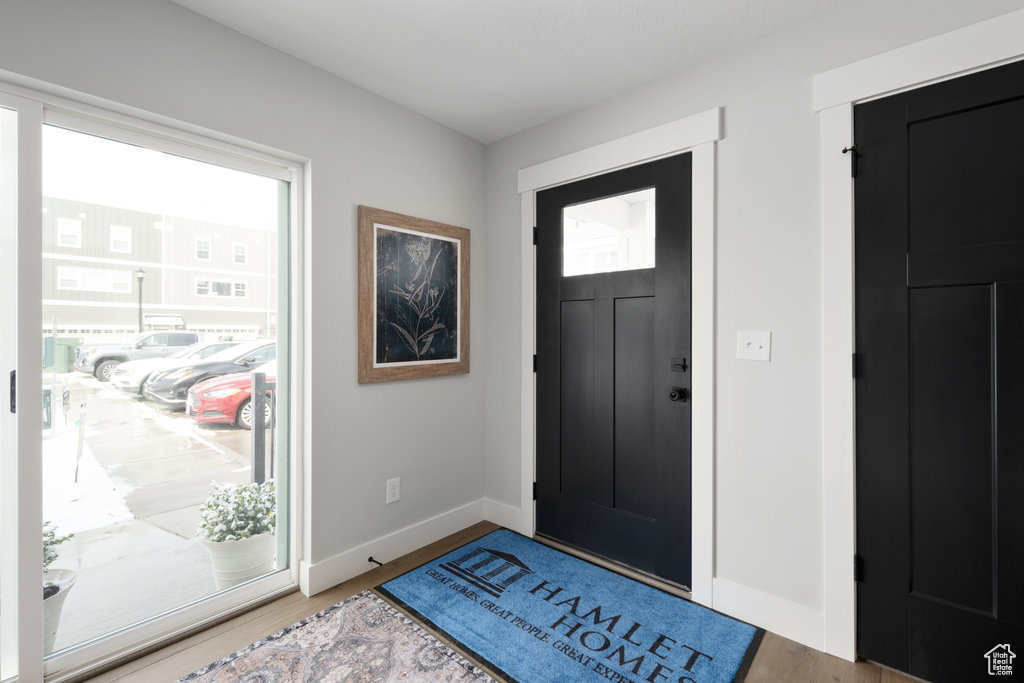 Foyer with baseboards and wood finished floors