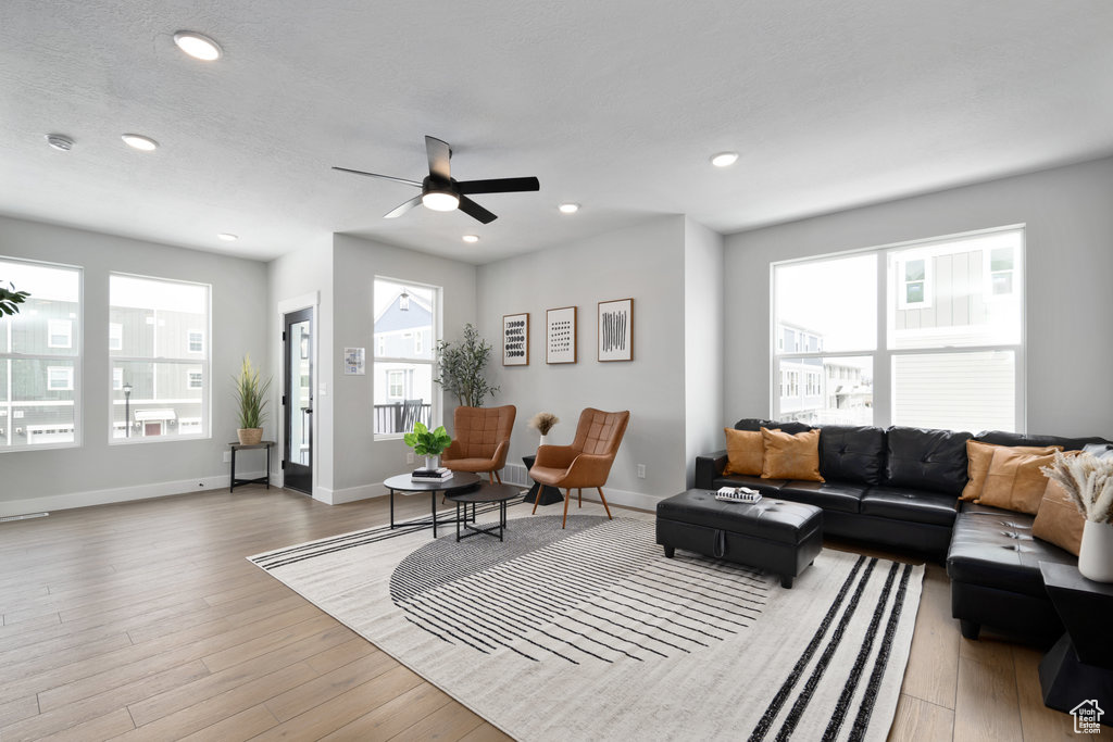 Living area featuring light wood-style floors, a ceiling fan, baseboards, and recessed lighting