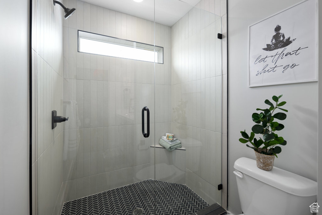 Full bathroom featuring toilet and a stall shower