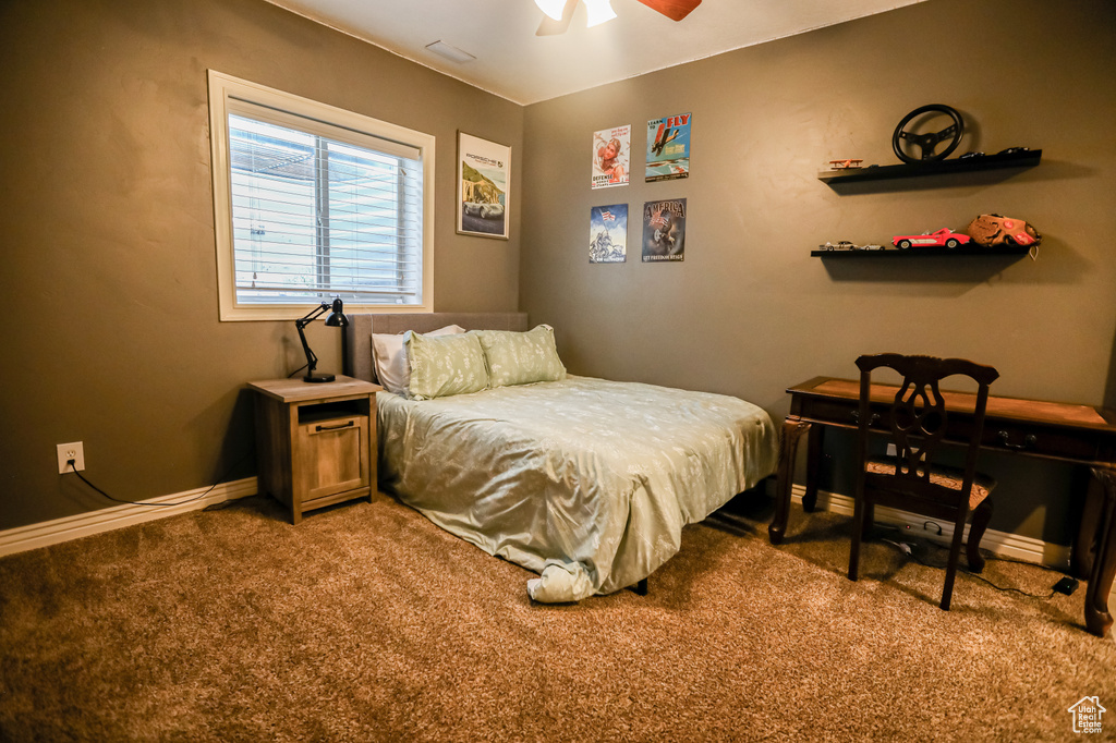 Carpeted bedroom featuring baseboards and ceiling fan