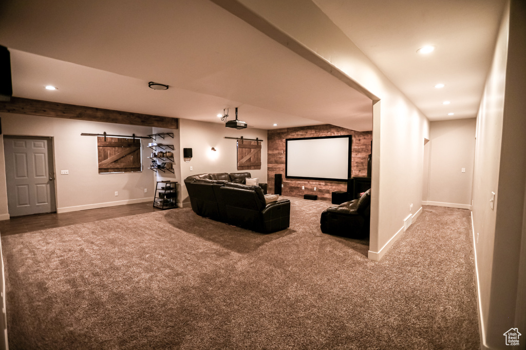 Carpeted cinema with a barn door, recessed lighting, and baseboards