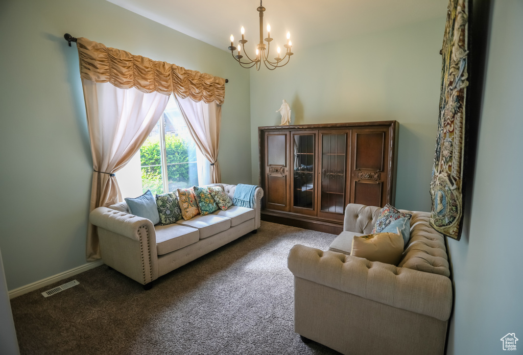 Living area featuring a chandelier and dark carpet