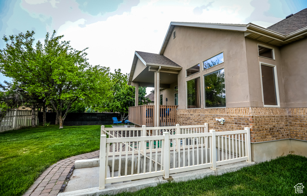 Back of property featuring stucco siding, brick siding, and a shingled roof