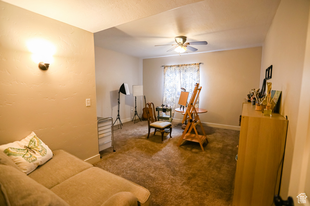 Living room featuring a ceiling fan, carpet floors, and baseboards