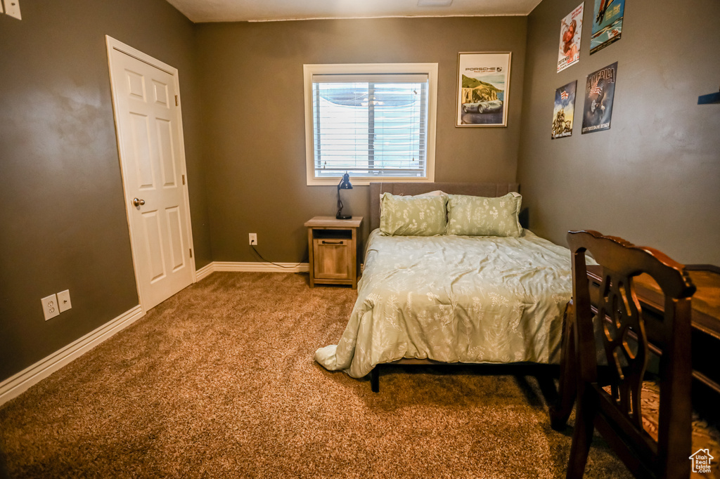 Bedroom featuring carpet and baseboards