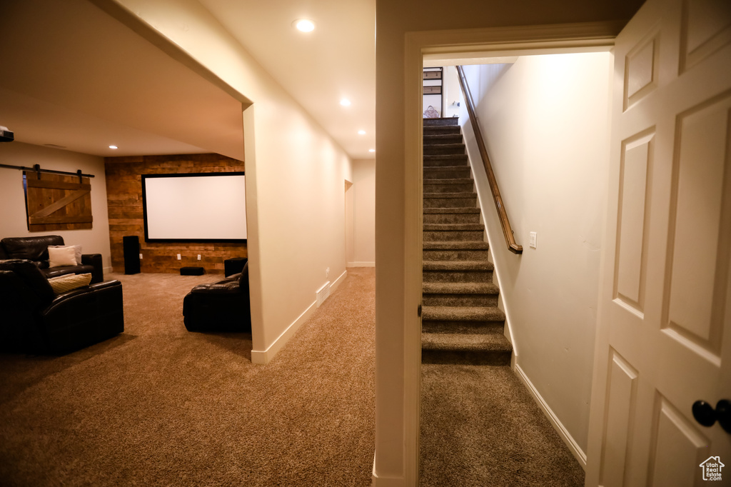 Carpeted home theater room with recessed lighting, a barn door, and baseboards