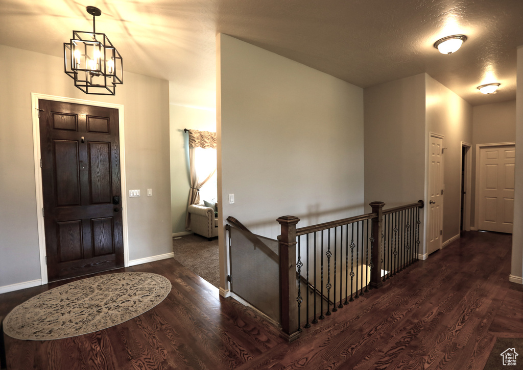 Foyer featuring a chandelier, wood finished floors, and baseboards