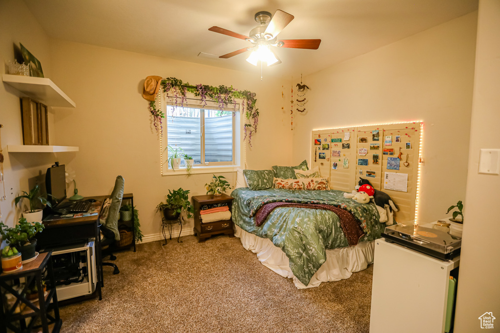 Bedroom with carpet flooring, a desk, ceiling fan, and baseboards