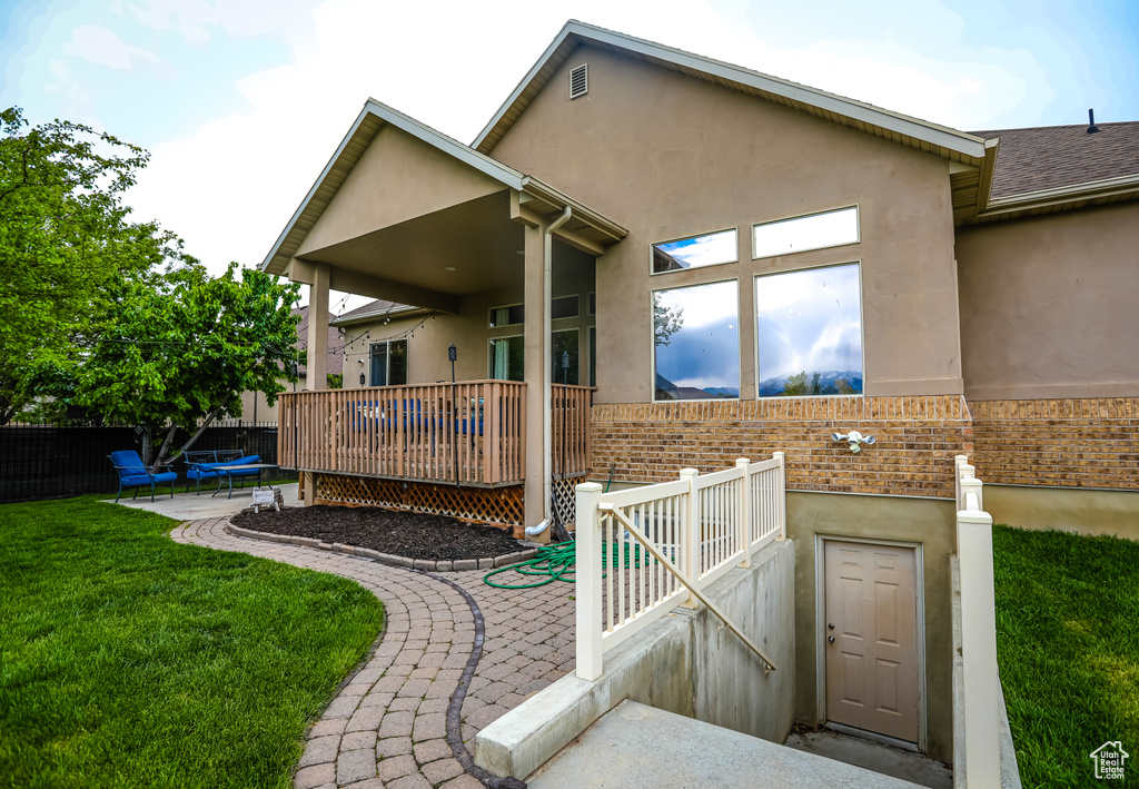 Back of house featuring brick siding, stucco siding, and a patio area