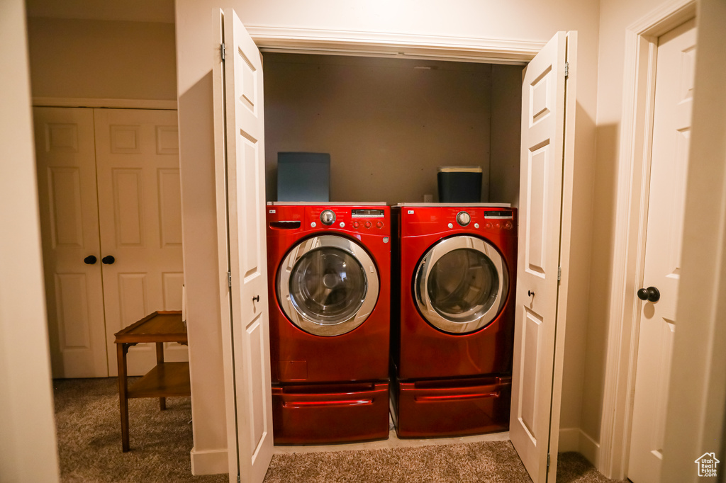 Laundry room with independent washer and dryer and carpet flooring