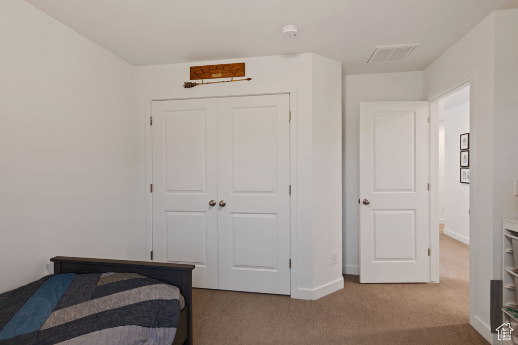 Bedroom with carpet flooring, baseboards, and a closet