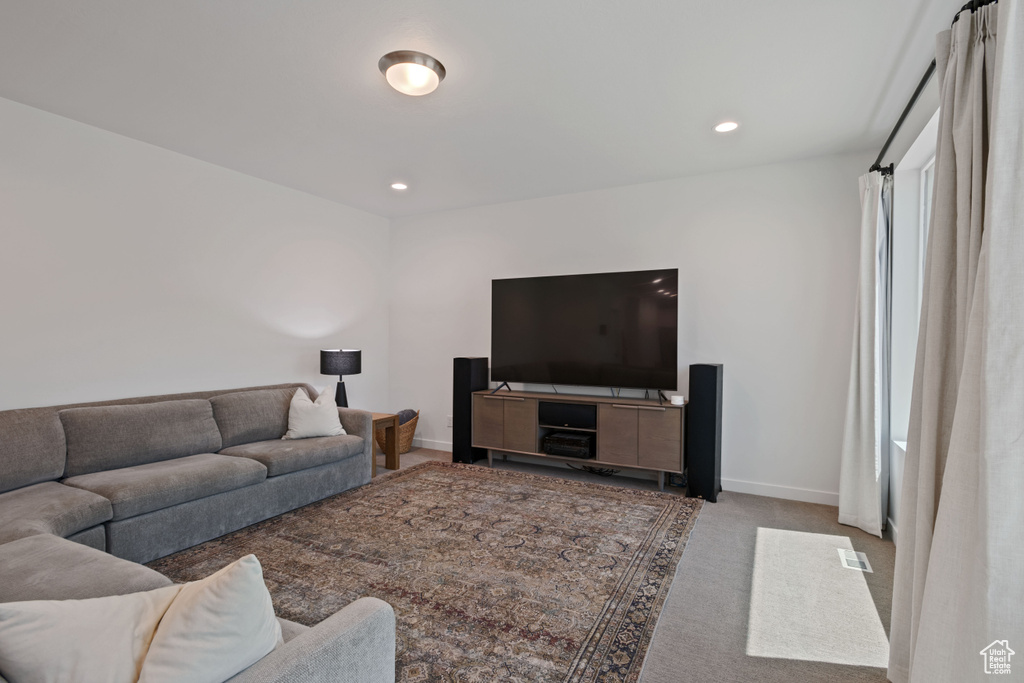 Carpeted living room featuring baseboards and recessed lighting