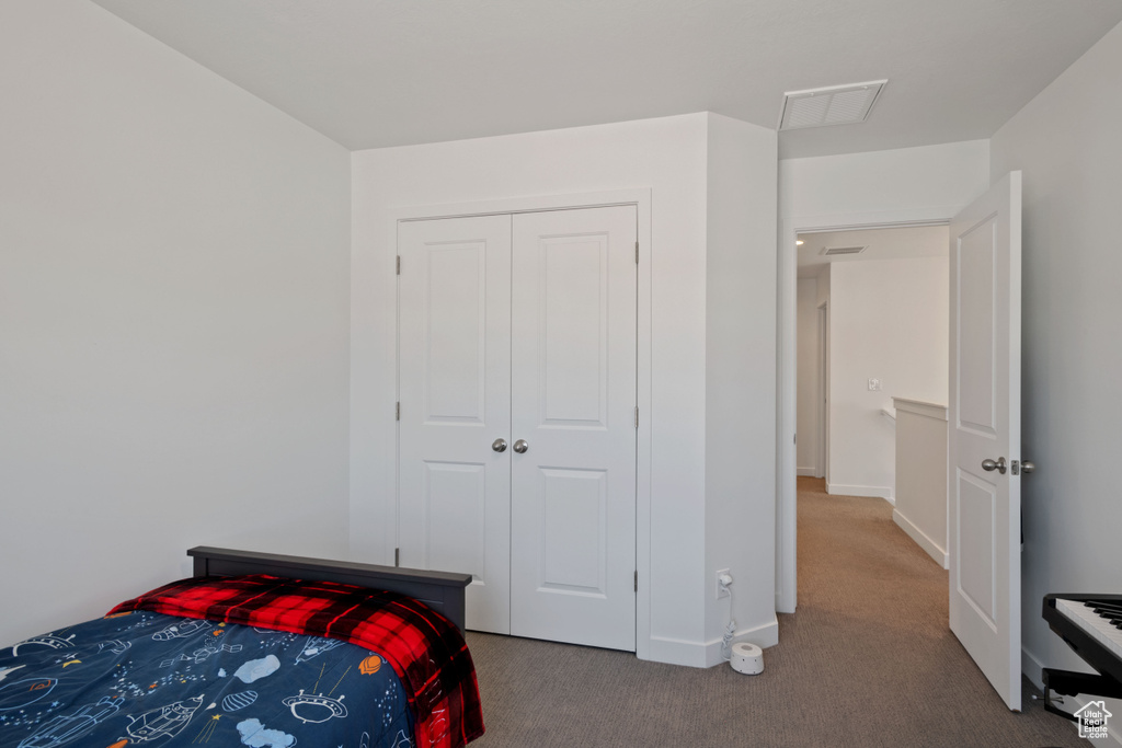 Bedroom featuring carpet, baseboards, and a closet