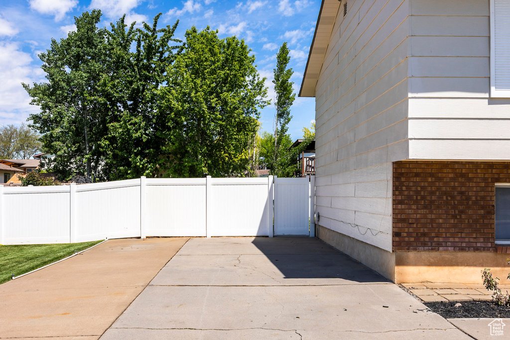 View of home's exterior featuring fence, brick siding, and a gate
