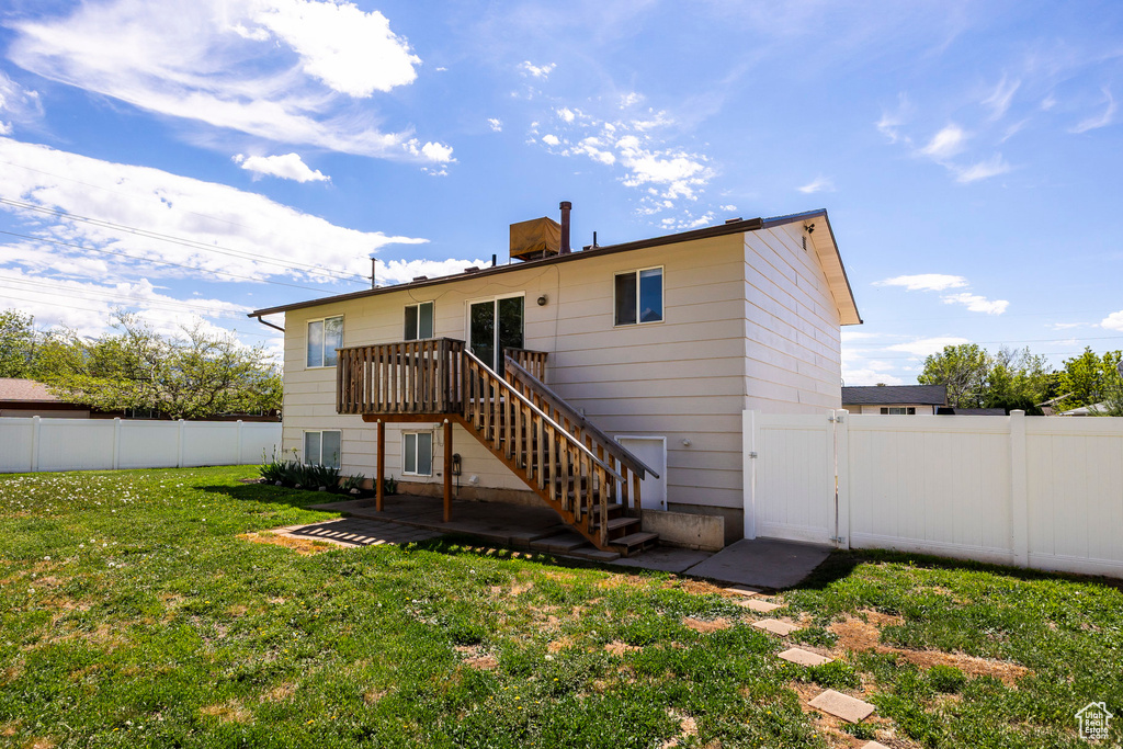 Back of house featuring a gate, stairway, a deck, and a patio