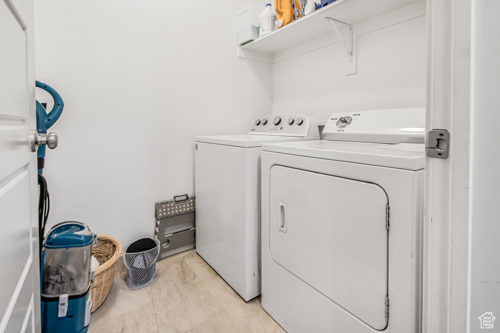 Washroom with washing machine and dryer and light marble finish floors