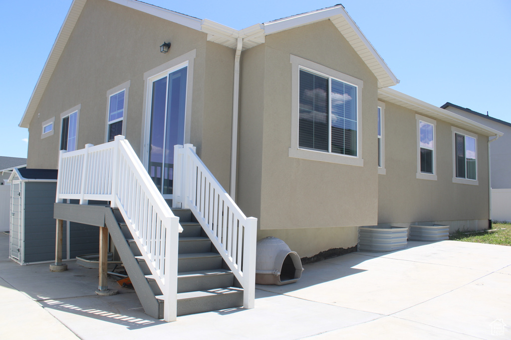 Rear view of house with a patio area and stucco siding